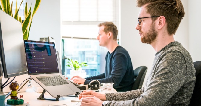 men working in front of laptops
